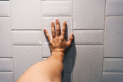 Close-up of hand on wet wall