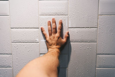 Close-up of human hand against wall