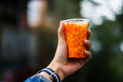 Close-up of hand holding orange juice