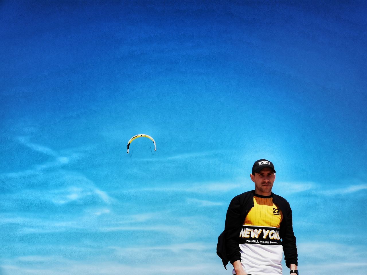 sky, one person, leisure activity, low angle view, sport, blue, front view, cloud - sky, parachute, real people, day, standing, flying, lifestyles, nature, three quarter length, paragliding, extreme sports, glasses