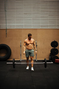 Shirtless man exercising in gym