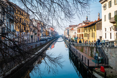 Canal amidst buildings in city during winter