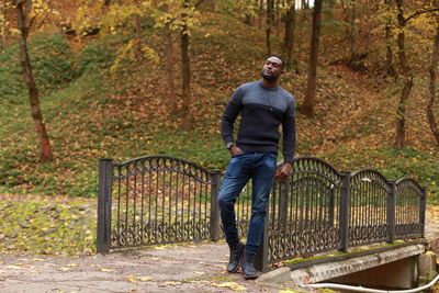 Full length portrait of a young man on field during autumn