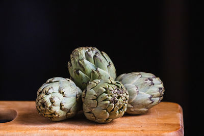 Still life of artichokes on a wooden board