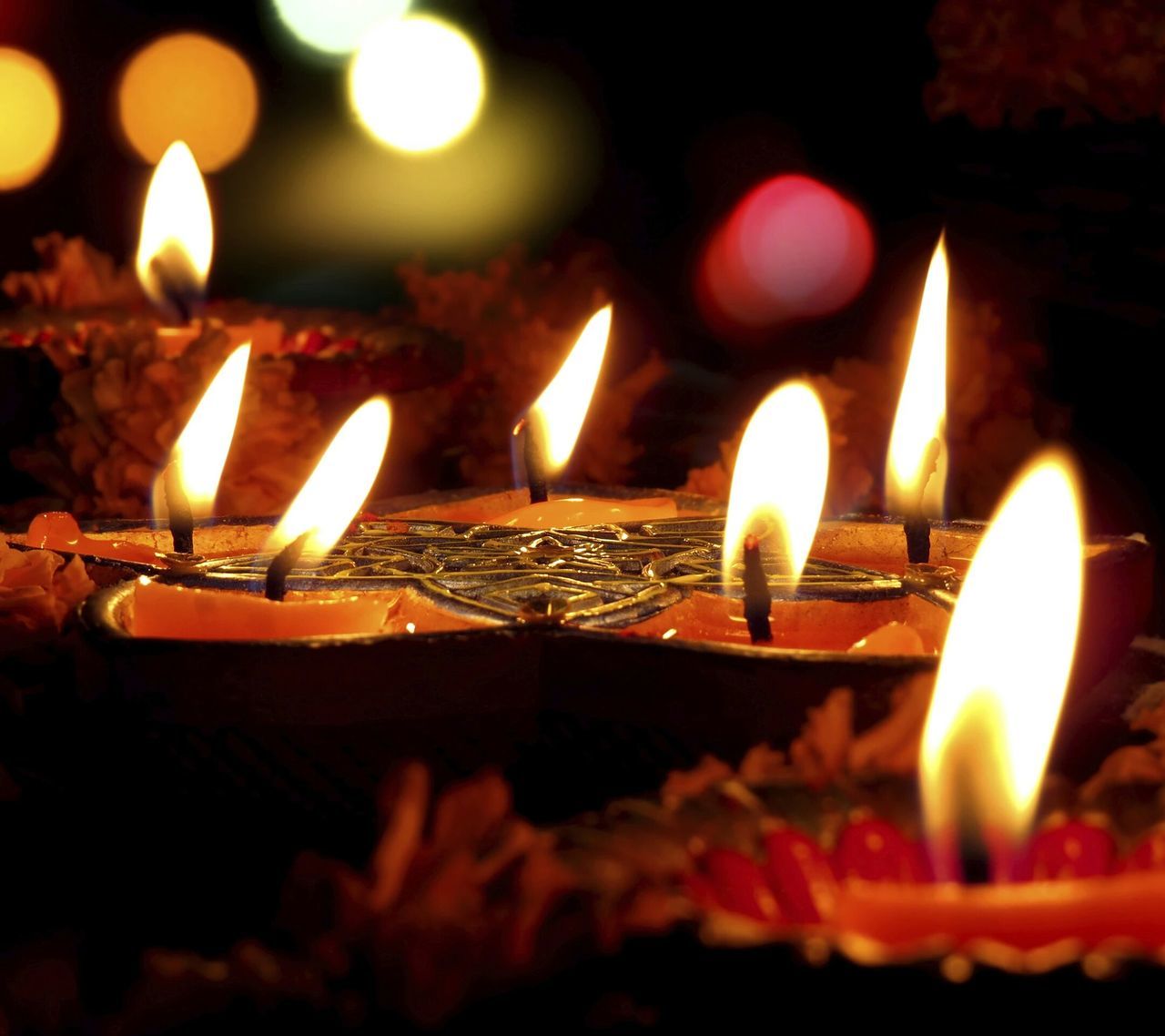 CLOSE-UP OF LIT CANDLES