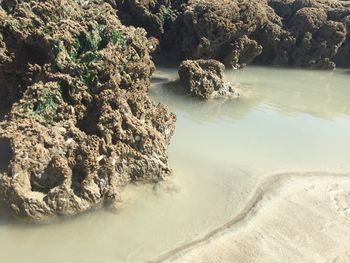 High angle view of rock formation in sea against sky