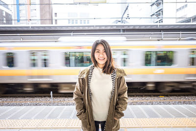 Full length of beautiful woman standing at railroad station