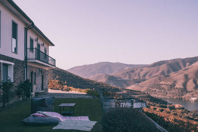 Houses by mountains against clear sky