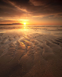 Scenic view of beach against sky during sunset