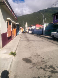 Sidewalk by mountain against sky