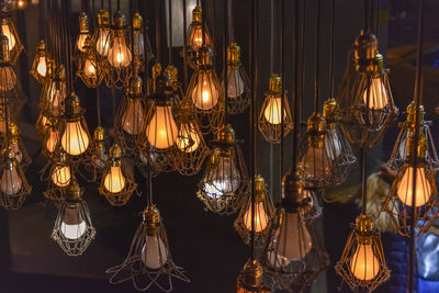 Close-up of illuminated light bulbs hanging from for sale