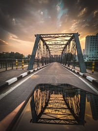 Bridge over calm river at sunset