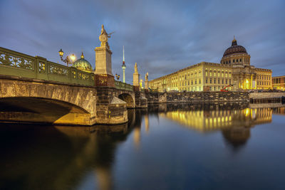 The rebuilt berlin city palace with the television tower at night