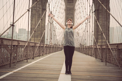 Full length of woman standing on bridge