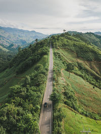 Road amidst green landscape against sky