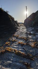 Road amidst rocks against sky during sunset