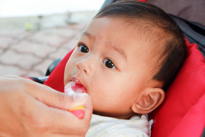 Cropped mother feeding baby boy