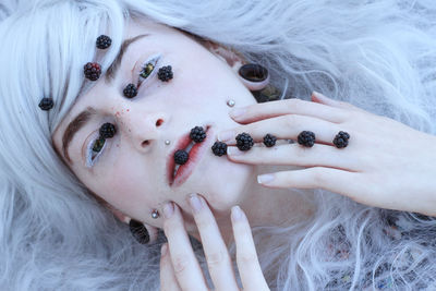 Directly above portrait of female model with blackberries