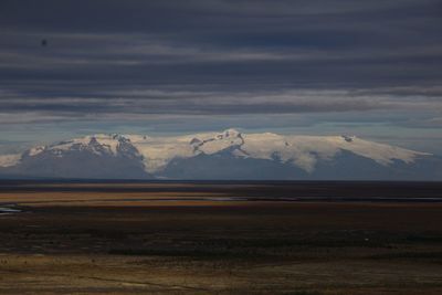 Scenic view of snowcapped mountain against cloudy sky