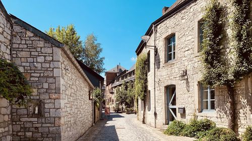 Footpath amidst buildings against sky