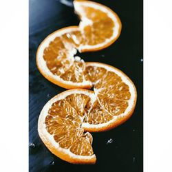 Close-up of orange fruit over white background