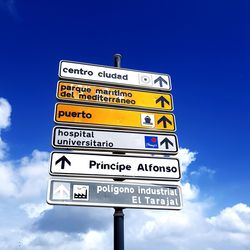 Low angle view of road sign against blue sky