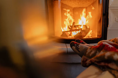 Low section of person against fireplace at home