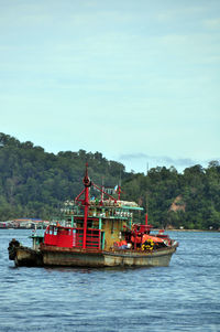 Boat sailing on river against sky