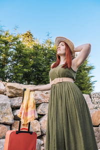 Portrait of woman standing against trees