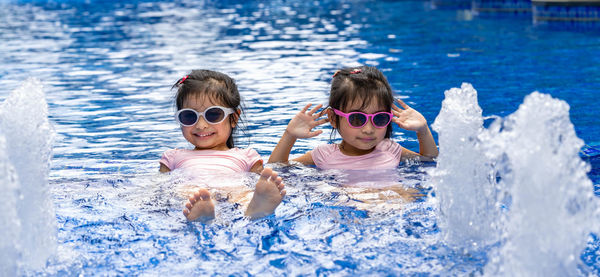 Portrait of friends in swimming pool