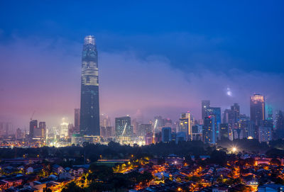 Illuminated buildings in city against sky