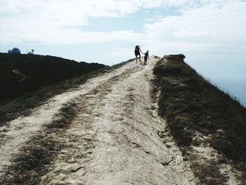 People walking on street amidst mountains against sky