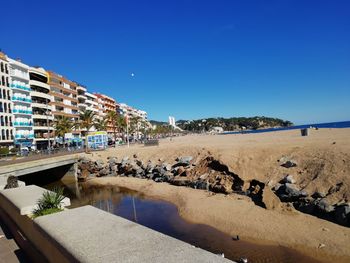 Scenic view of beach against clear blue sky