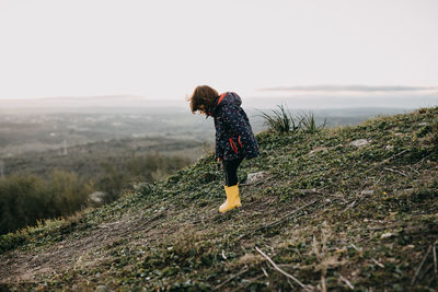 Full length of girl standing on landscape