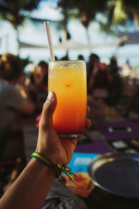 Cropped hand holding drinking glass