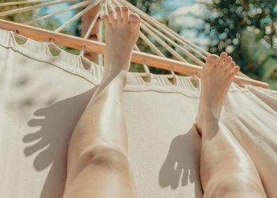 Low section of woman relaxing on hammock