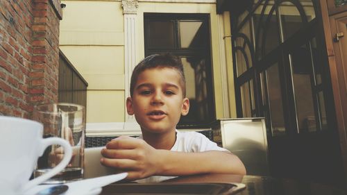 Portrait of boy using mobile phone at table