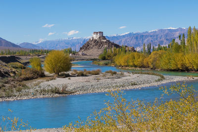 Scenic view of river and landscape against blue sky