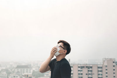 Full length portrait of man standing against cityscape