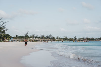 People on beach against sky