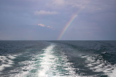 Scenic view of rainbow over sea against sky