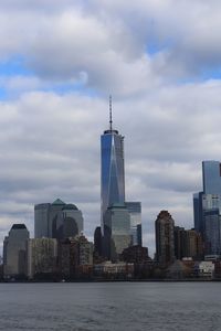 Sea by buildings against sky in city