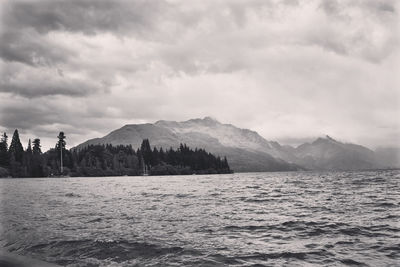 Scenic view of sea and mountains against sky