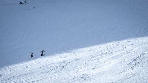 People skiing on snow covered landscape