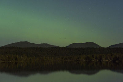 Scenic view of lake against sky at night