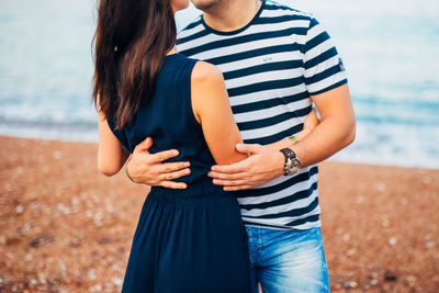 Midsection of woman standing by sea