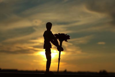 Silhouette man standing against sky during sunset