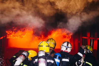 Rear view of firefighters extinguishing fire