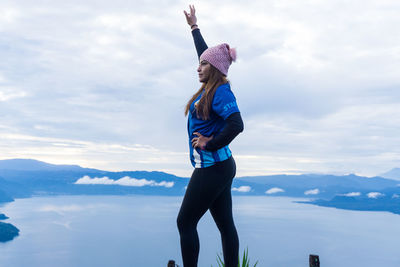 Woman standing on snow covered mountain against sky