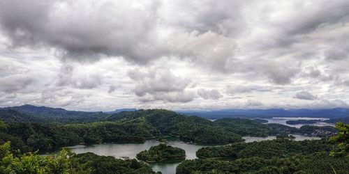 Scenic view of river against cloudy sky